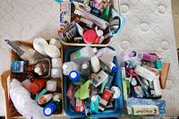 Top overview photo showing three baskets filled with various bottles and containers of toiletries and personal care products.