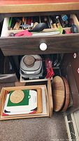 Drawer with assorted cooking utensils including spatulas, whisks, ladles, and cooking spoons with wood, plastic, and metal handles.