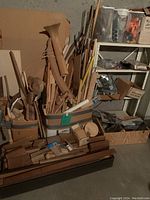 Overview of various scrap wood pieces, baskets and boxes filled with wooden dowels, carved shapes, and walnut trim wood pieces.
