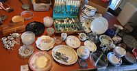 Entire collection of assorted silverware, ceramic plates and bowls, glass plates and decorative items displayed on a table