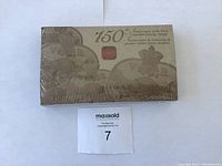 Sealed rectangular souvenir box with embossed images of Canadian stamps and 150th anniversary inscription