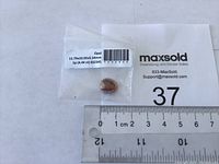 Boulder opal gemstone in clear plastic bag with measurement ruler showing size relative to centimeters.