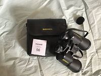 Bushnell binoculars and carrying case laid out with lot number tag