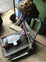 Two children's scooters stacked with a brown helmet on top
