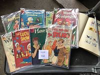 Assorted vintage comic books including Walt Disney's Comics, Woody Woodpecker, The Lucy Show, Sgt. Bilko with colorful covers in plastic sleeves.