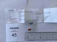 Photo of two round matching fire opal gemstones in a small transparent bag with size ruler and paperwork showing specs.