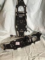 Pair of Snow Mountain snow shoes with labels and adjustment straps visible