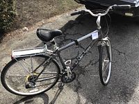 Left side view of entire bicycle showing frame, wheels, saddle, rear rack