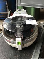 Closed view of the T-fal air fryer showing the transparent lid, handle, and control panel with buttons and indicator lights.