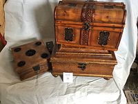 Photo showing all three wooden boxes in a single image on a white cloth background.