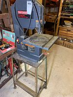 Full view of Craftsman band saw mounted on metal stand in workshop