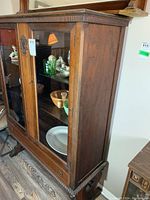 Full cabinet view showing two glass doors with displayed items inside and drawer at the bottom