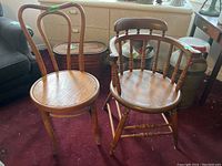 Photo showing both wooden chairs side by side on carpeted floor in used condition with visible scratches.