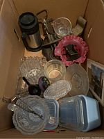 Overview of entire box contents showing various glass trays, bowls, measuring cups, mixer, thermos, and sock darners.