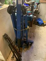 Folded hydraulic engine crane on castors with removable handle sections strapped