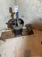 Full view of the vintage sausage stuffer and meat grinder mounted together on a wooden base, showing overall condition and setup.