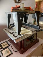 Side angle of Craftsman router table with black legs and orange top motor.