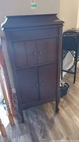 Front view of the upright wooden Columbia Grafonola Victrola cabinet with double doors closed, showing dark wood finish and cabinet shape.