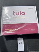 Front view of sealed mattress protector packaging showing brand, size, and protective feature labels