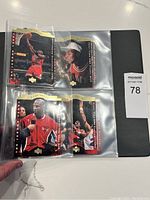 Four Michael Jordan Chicago Bulls basketball cards in plastic sleeves in a binder, showing various poses and moments from his career.