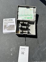 Box containing three metallic RCBS reloading dies and instruction manual with reloading data sheet.
