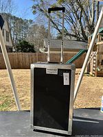 Front view of black rolling case with extended handle and Georgia Case label.