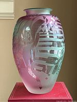 Front and one angled side view of handmade glass vase showing pink and turquoise colors, frosted and glossy textures, abstract patterns.