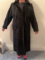 Full front view of the long reversible fur coat worn with fur side out