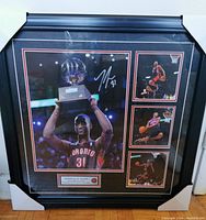 Full view of the black framed memorabilia showing four basketball photos of Terrence Ross and plaque