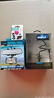 Boxed rearview mirror smartphone holder with adjustable arm and box of clip-on rotating holder