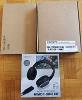 Top view of three boxes: Vistatech wireless headphone kit box, Linksys router box, and another large brown box.