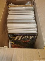 Cardboard box filled with plastic sleeve-protected comics, front issue is The Flash with 'From the Dark Beyond' storyline