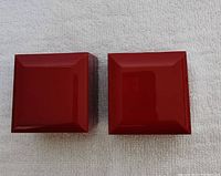 Two red lacquer James Allen jewelry boxes on white cloth