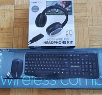 VistaTech wireless keyboard and mouse combo packaged in original box with VistaTech HDTV wireless headphone kit box on top, showing front side and product images.