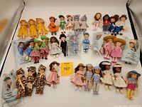 Wide view of all 35 Madame Alexander dolls laid out displaying variety of outfits and packaging.