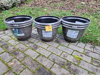 Three Southern Patio Hudson planters displayed outdoors on a stone surface showing size and color.
