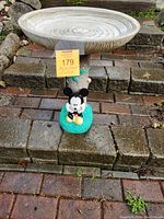 Front view showing full birdbath with Mickey Mouse at base and large circular basin on top.