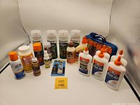 Full lot of glues and spray lacquers displayed on white background showing variety and condition.