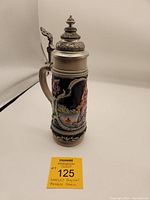 Full side view of the beer stein showing painted scene and handle with pewter lid.