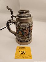 Full view of the vintage limited edition ceramic beer stein showing detailed multicolor relief design, pewter lid, and sculpted handle.