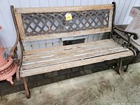 Front view of wood and wrought iron bench showing wooden slats seat and backrest frame with lattice iron inset.