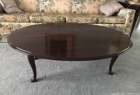 Side view of the mahogany coffee table showing length, shape, and leg style.