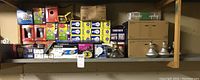 Shelf containing multiple boxes and loose packs of assorted light bulbs including Philips and others