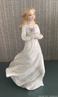 Front view of the Royal Doulton figurine with the woman holding the teddy bear.