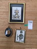 Overall view showing two framed horological collages and one framed Queen Elizabeth II memorabilia piece on a wood surface.