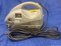Front view of gray Kodiak pressure washer showing carry handle, power switch, and attached power cord, marked 4000 PSI.