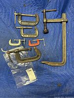 Full lot view with all 8 C clamps laid out on a blue padded surface.