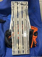 Folded aluminum workbench showing slatted surface and wear marks