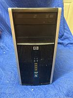 Front view of the HP desktop tower with visible power and optical drive bays.