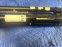 Close-up of Manfrotto label and folded tripod legs showing model number 475B and lot number sticker.